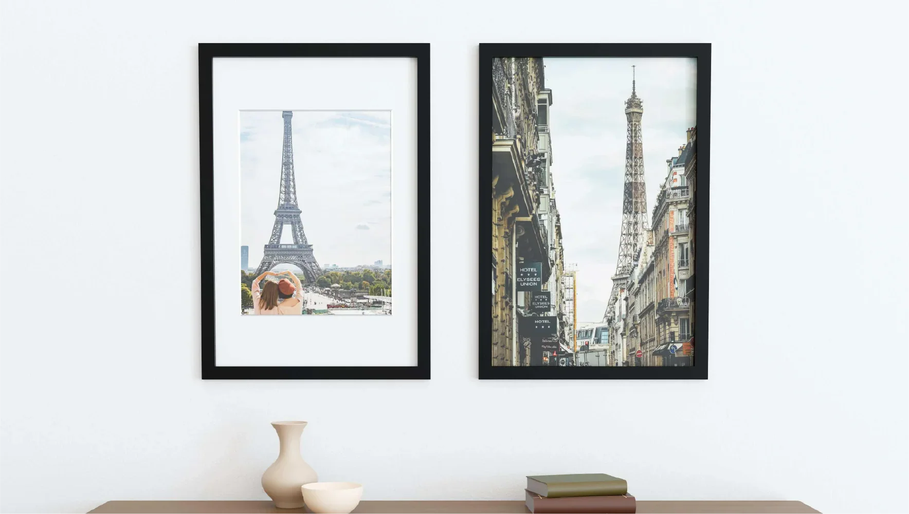 Two 24x36 picture frames featuring black solid wood borders and tempered glass covers hung up on a wall.