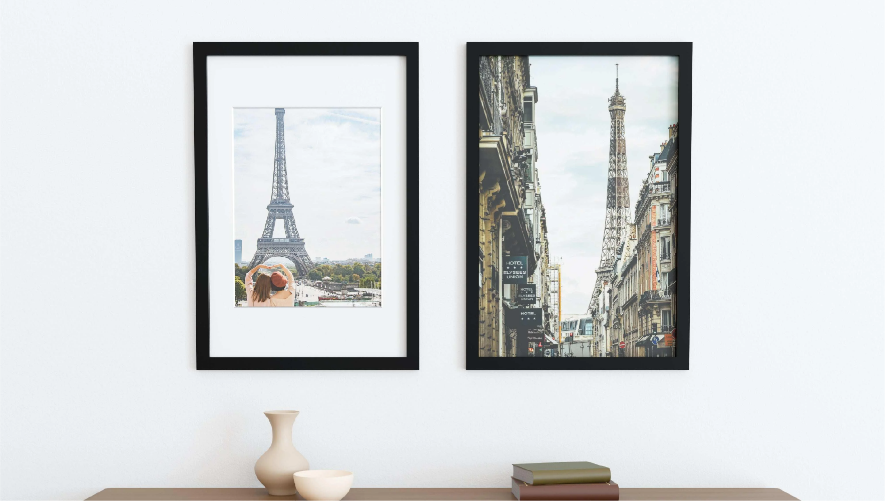 Two 24x36 picture frames featuring black solid wood borders and tempered glass covers hung up on a wall.